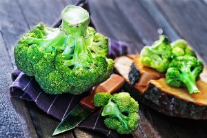 raw brocoli and knife on the wooden background